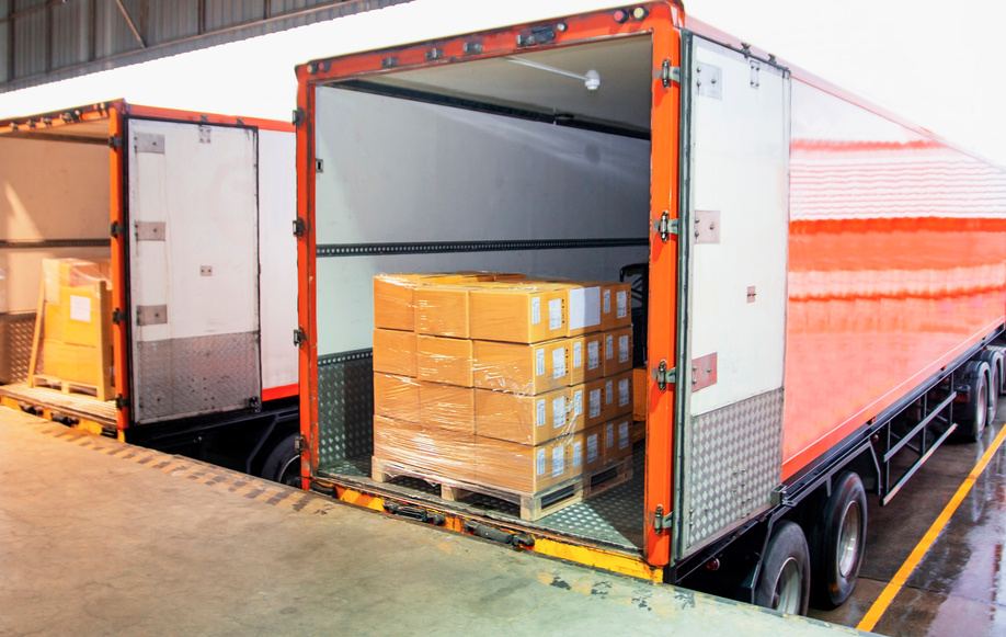 Caja de tráiler abierta con tarimas en proceso de carga